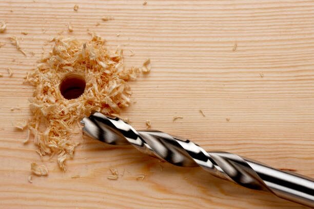 A drill bit with a hole in it on a wooden table.