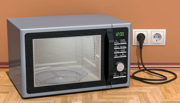A microwave is sitting on a wooden floor