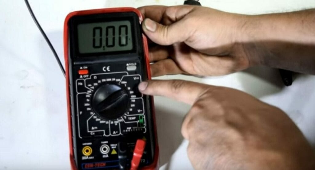 A person turning the multimeter to DC settings