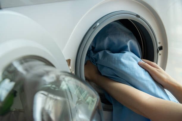 A person is operating an electric washing machine
