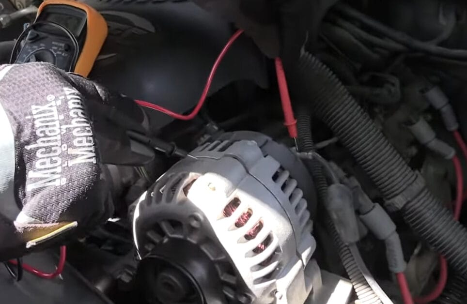 A person is troubleshooting an alternator in a car to determine if it can ruin a battery