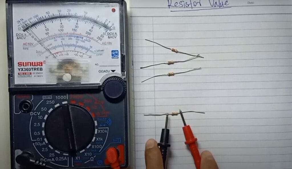 A person is using a multimeter to measure the voltage of a resistor