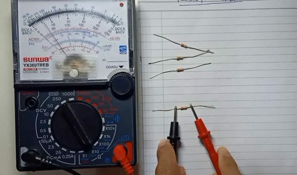 A person is using a multimeter to test the resistance of a wire