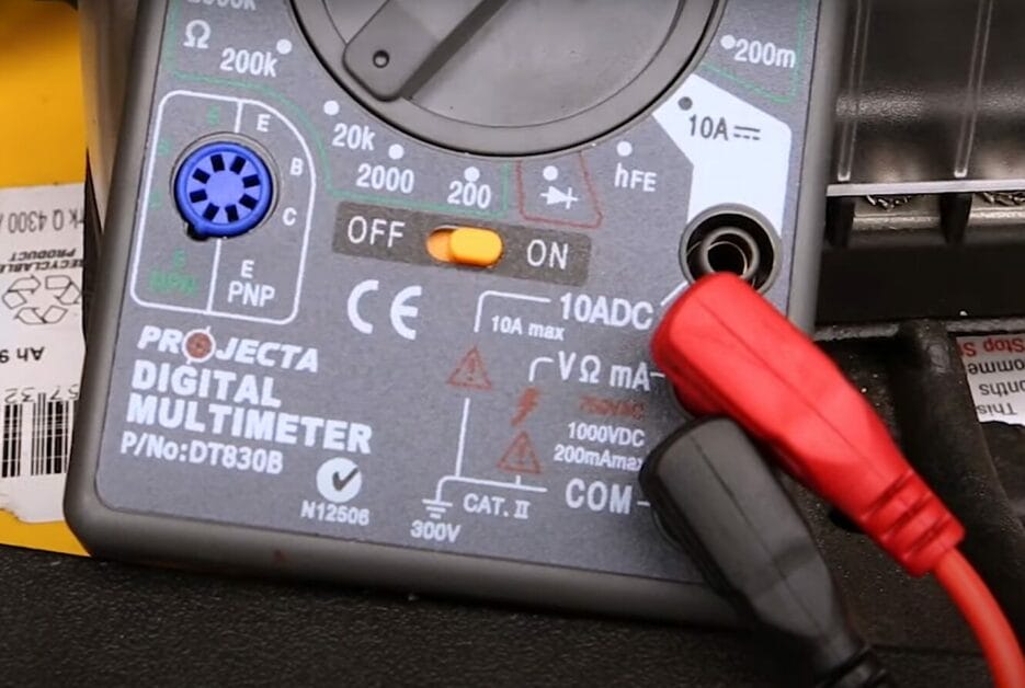 A digital multimeter with its probe connected on it