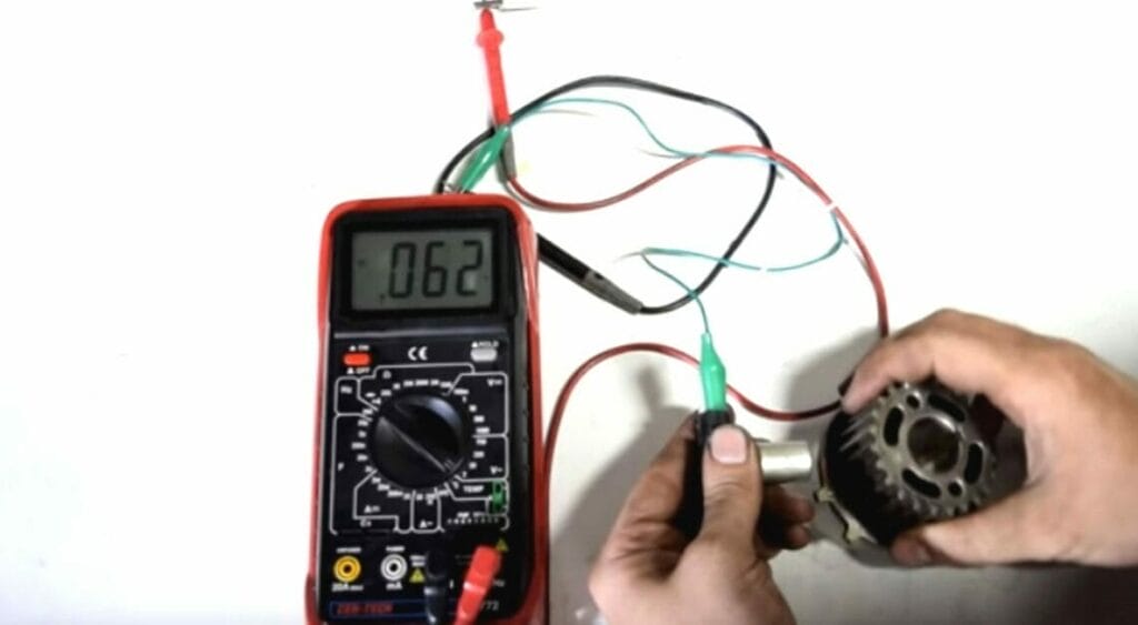 A person passing an object over the CKP Sensor to measure the voltage
