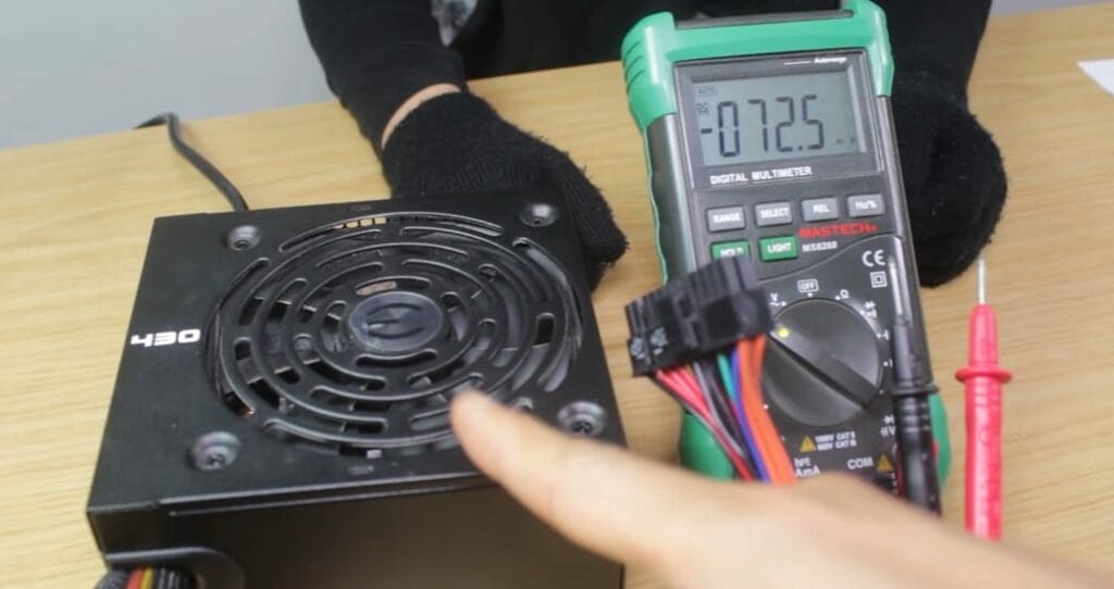 A person is using a multimeter to test the power supply