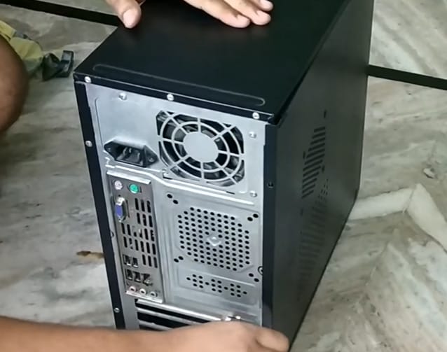 A man is opening the back of a CPU