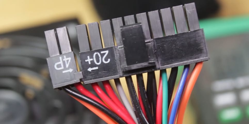 A close up of a wire connected to a computer used in testing PC power supply