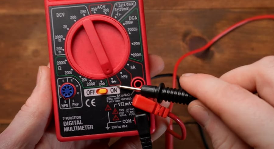 A person is holding a multimeter set