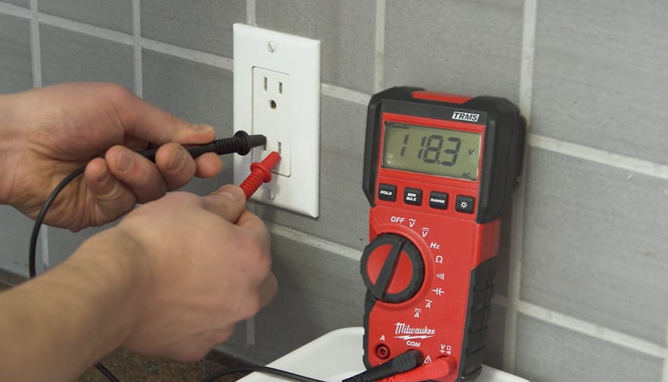 A person testing the outlet with 118.3 reading in it