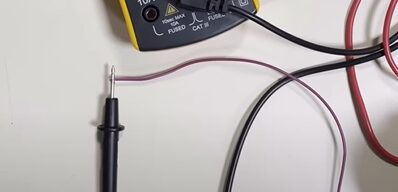 A multimeter with wires attached to its probe