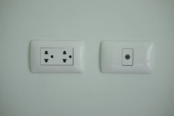 Two different electrical outlets on a white wall