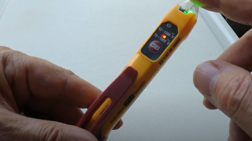 A person is holding a non-contact voltage tester