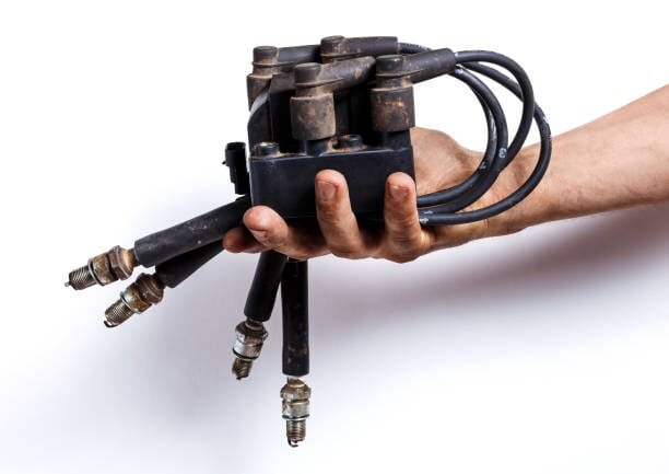A man demonstrating how long spark plug wires last by holding a bunch of wires in his hand