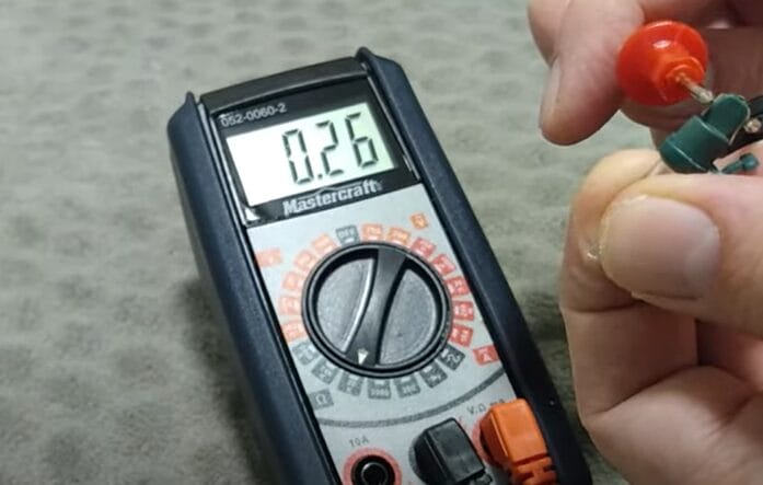 A person using a multimeter to test a battery for Christmas lights