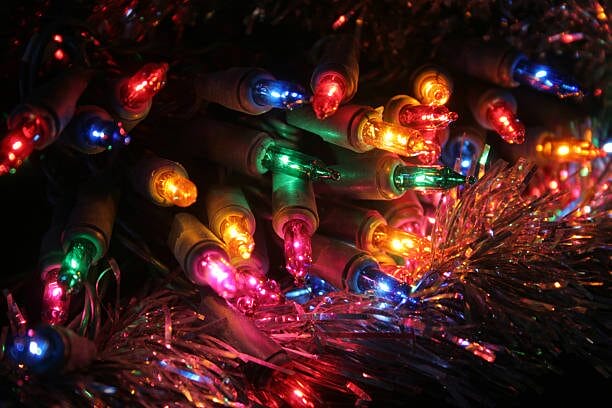 A close up of Christmas lights tangled in tinsel