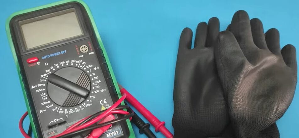 A pair of gloves and a multimeter used to check 240 voltage on a blue background.