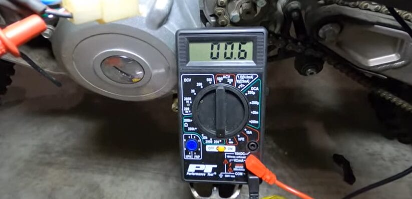 A multimeter is used to test a motorcycle engine's stator