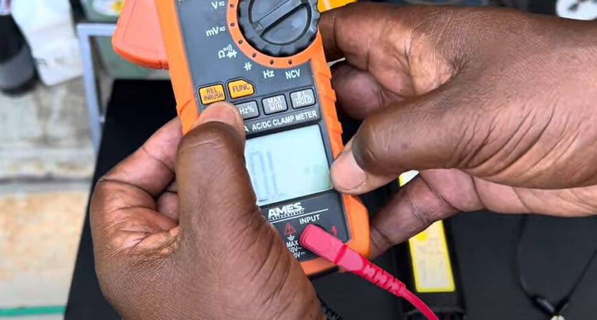 A person demonstrating how to test a ballast with a multimeter
