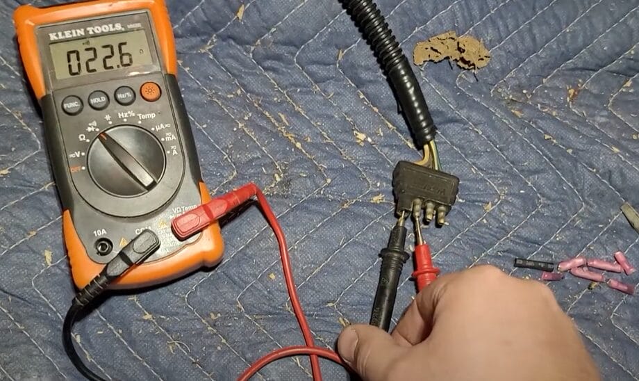 A person using a multimeter to test trailer lights