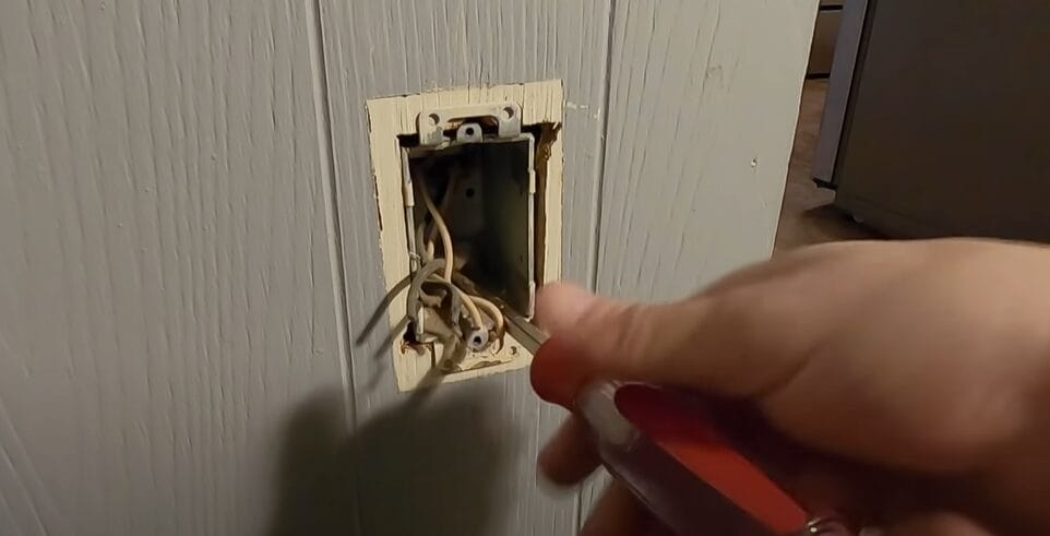 A person disconnecting wires in a junction box