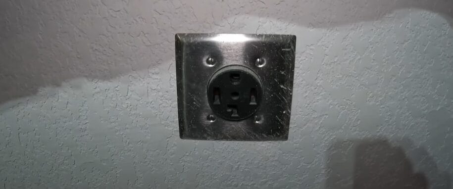 A 4-prong black outlet on the wall