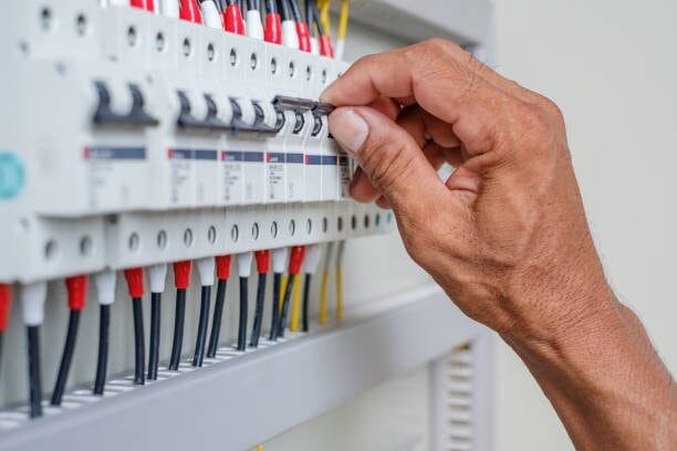 A person performing a check on a circuit breaker