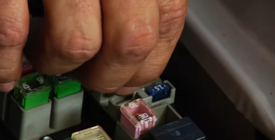 A zoom in image of a hand checking a car fuses on its terminal