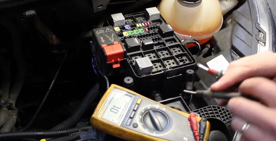 A man testing car fuses with a multimeter