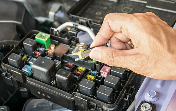 A person is testing car fuses