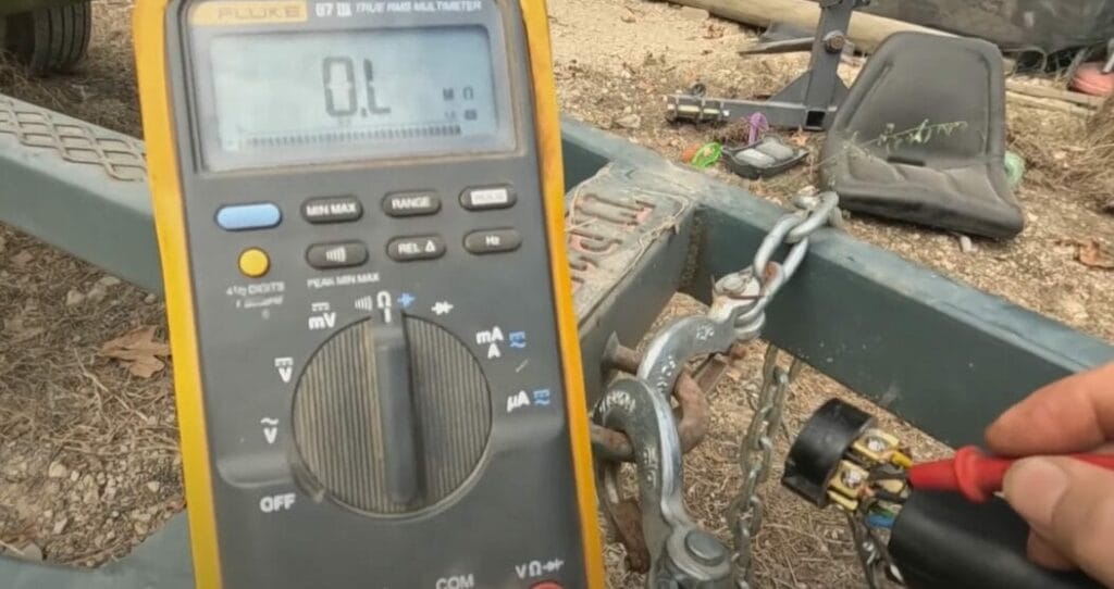 A person is using a digital multimeter to test a battery.