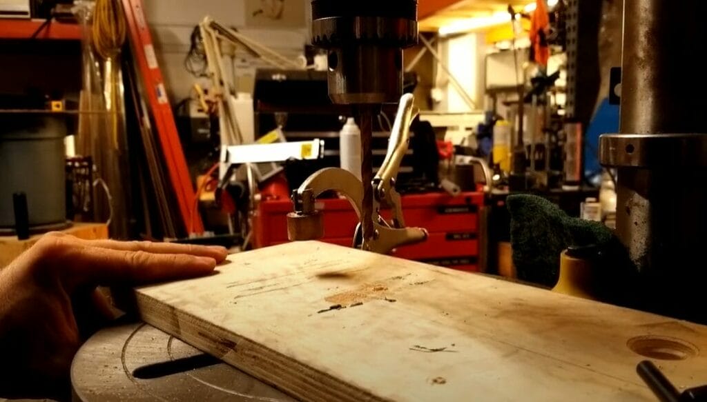 A person is holding a piece of wood in a workshop