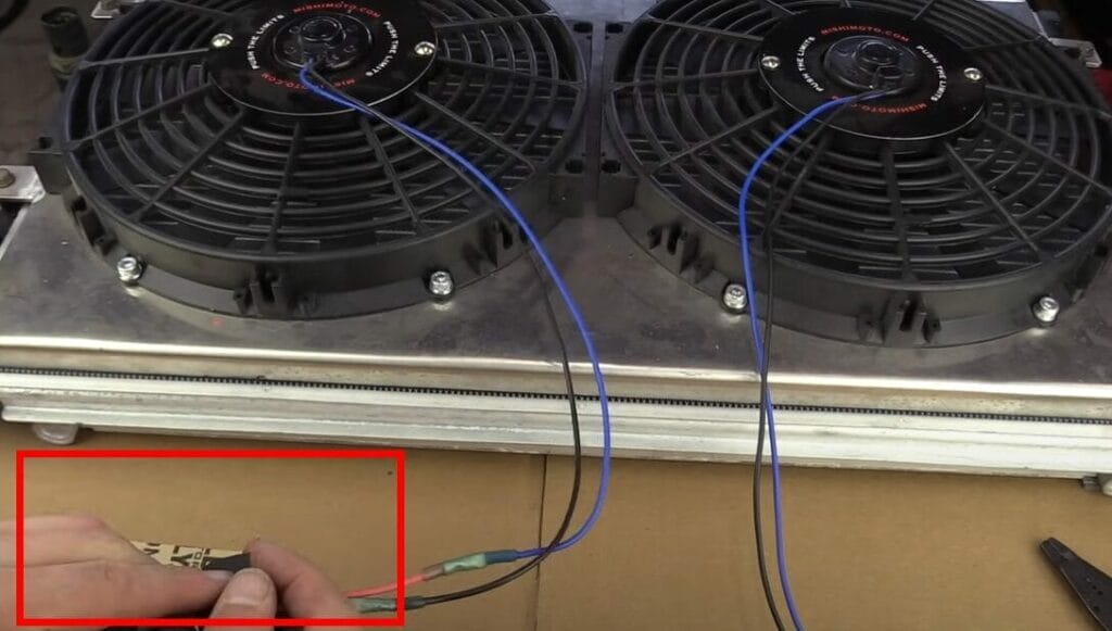 A blue wire being connected to a fan