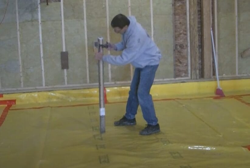 A man holding a pole while using a laser level for grading