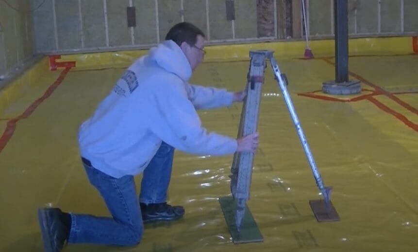 A man skillfully operating a laser level while working on a floor
