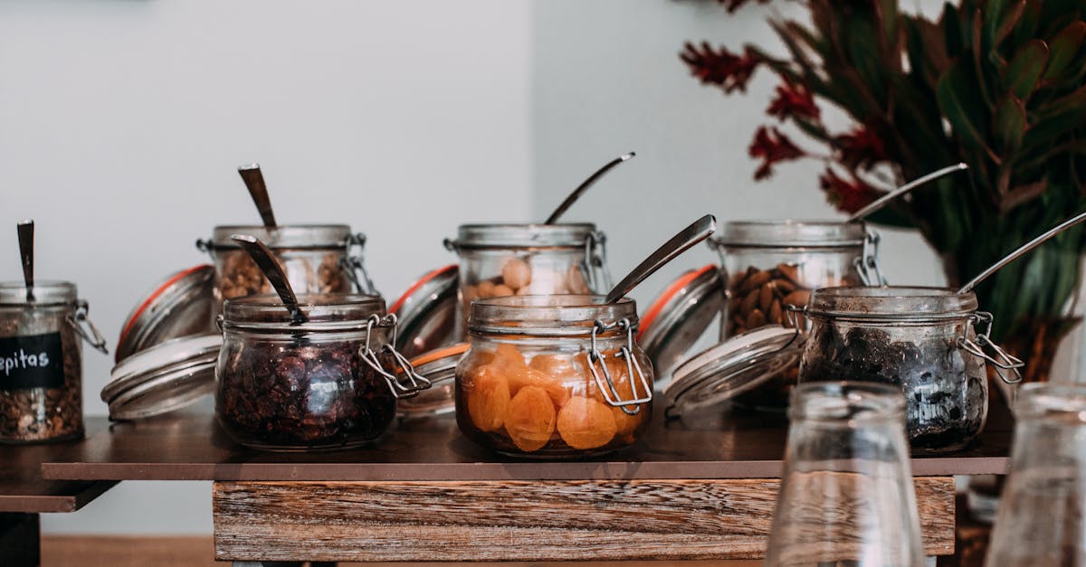 assorted dried fruits and nuts in transparent jars on table