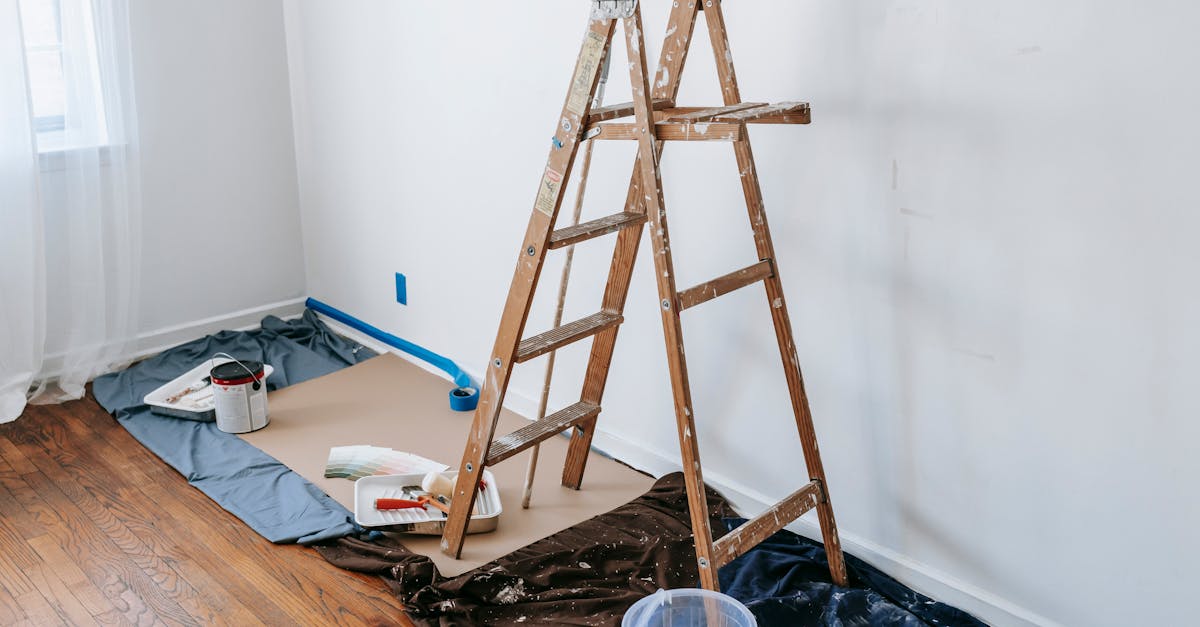 a room with a stepladder and painting tools showcasing a renovation process