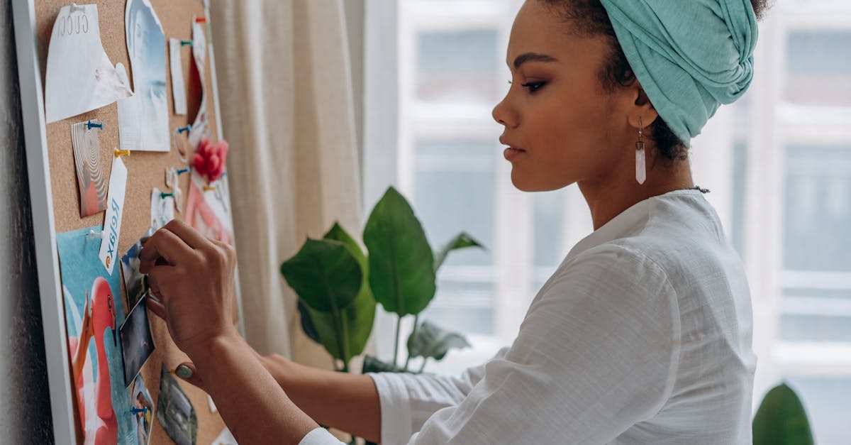woman creating a vision board with images in a stylish home setting showcasing creativity and focus
